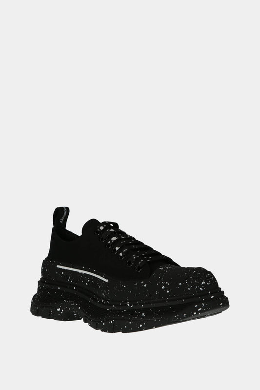 Black "Tread Slick" low top sneakers with white paint stains