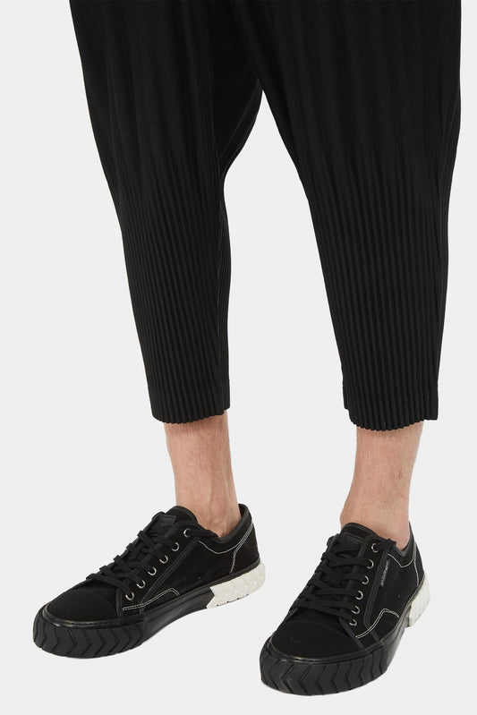 Issey Miyake Pantalon noir écourté à design plissé - LECLAIREUR